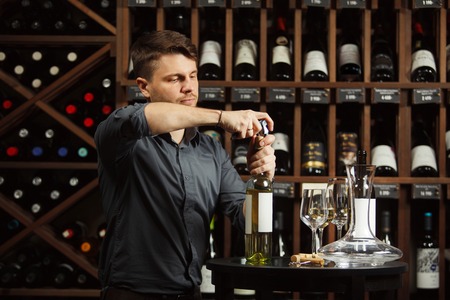 Sommelier opening white wine bottle with corckcrewの写真素材