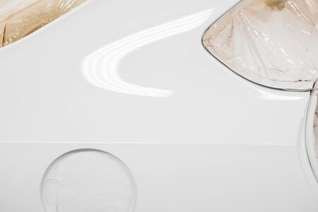 Close-up painted car body in white. Painting with a spray gun.の写真素材