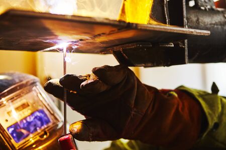 Man in protective mask welding metal construction.の写真素材
