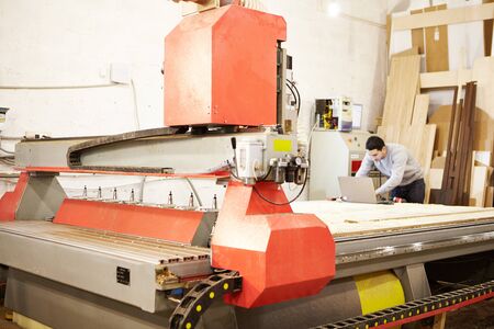 Cnc machine at carpentry workshop. Cutting wood with various router bits. Woodwork industry.