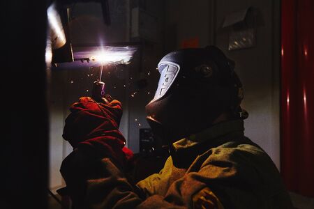 Welder in protective mask welds steel constructions.の写真素材