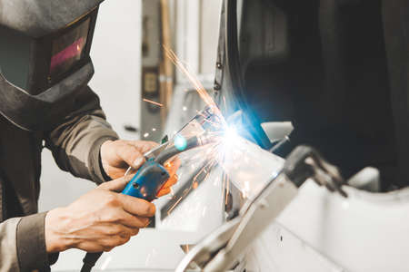 Metal working car body with carbon dioxide welding machine. Repair of vehicle in service to restore...