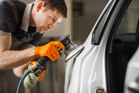Sanding of uneven elements of the car after painting and varnishing. Vehicle repair in service station.の写真素材