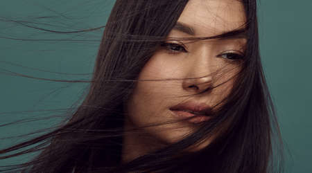 Beautiful girl with smooth, silky dark brown flying hair.の写真素材