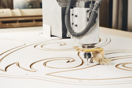 Numerically controlled woodworking machine cuts rounded complex lines on the canvas. Computer...