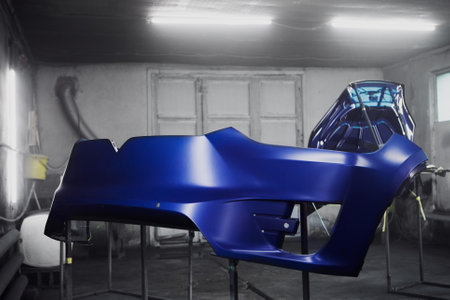 Painted car bumper in auto service. Restoration painting of automobile in paint chamber service.の写真素材