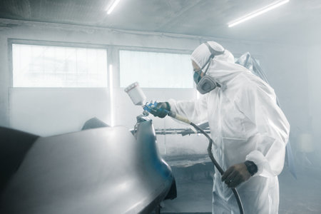 Car paint job by professional worker, car painting procedure in car service, body paint garage.の写真素材