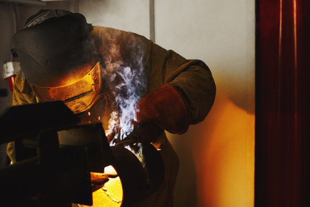 Close-up image of industrial worker at the factory welding.