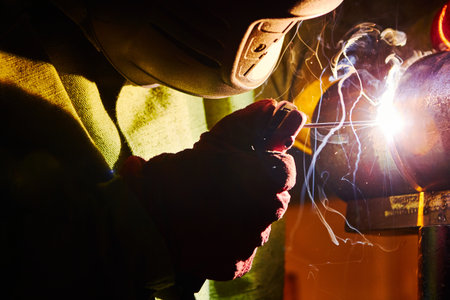 Close-up image of industrial worker at the factory welding.