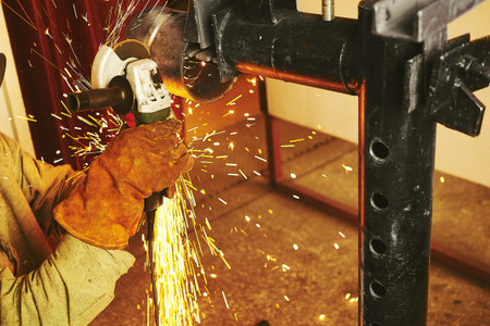Horizontal close-up of cutting steel with machine for cutting steel by worker