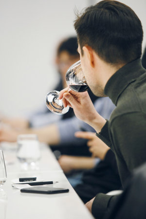 Concentrated Sommelier Evaluating Red Wine Being in Wine School, Vertical Back Close up Portraitの写真素材