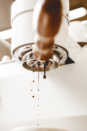 Freshly Brewed Espresso Pours From Bottomless Portafilter of Professional Coffee Maker Showcasing Thick Trickle of Rich Crema, Bottom Viewの写真素材