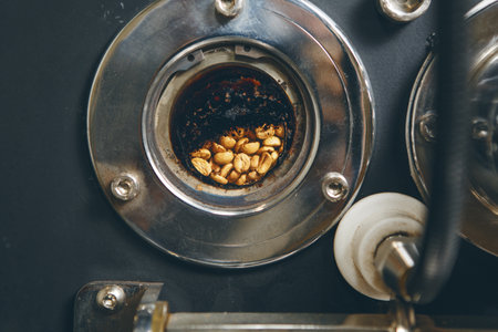 Close-up photo of professional coffee roaster with having small round window revealing visible of roasted coffee beans for analysis it level of roast. Professional coffee roasting equipment.の写真素材