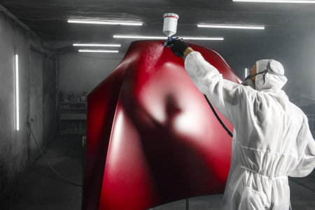 Car paint job by professional worker, car painting procedure in car service, body paint garage.の写真素材