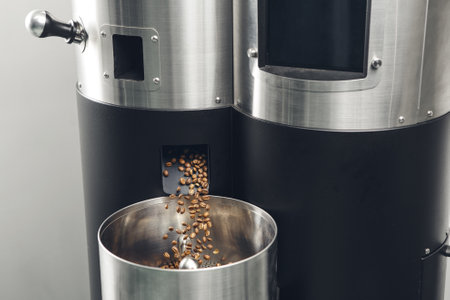 Roasted Coffee Beans Pouring From Roaster Into Cooling Tray Bin
