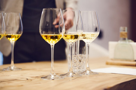Elegant wine glasses with different white and sparkling wines on the table during the preparation for the tasting.の写真素材