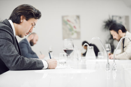 Professional Sommeliers Participants Tasting Red Wine during Blind Degustation. Contest in Sommelier...