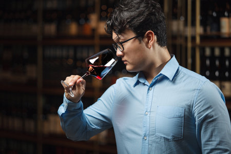 Professional Sommelier Evaluating Red Wine in Cellar Environment