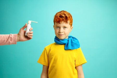 Seasonal Colds in Children Concept. Little Red Headed Boy Wrapped in a Scarf Preparing to Take Cough...