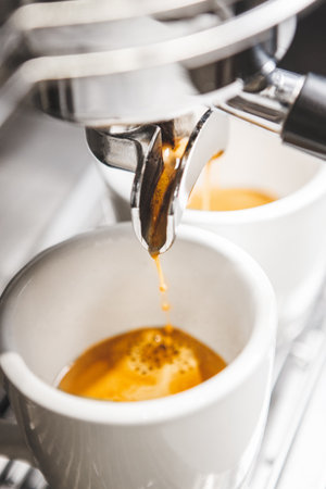 Close-up of Freshly Brewed Espresso With Rich Crema Being Poured Into White Cups From Holderの写真素材