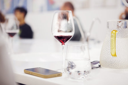 Wine glass poured with red wine on table during training.の写真素材