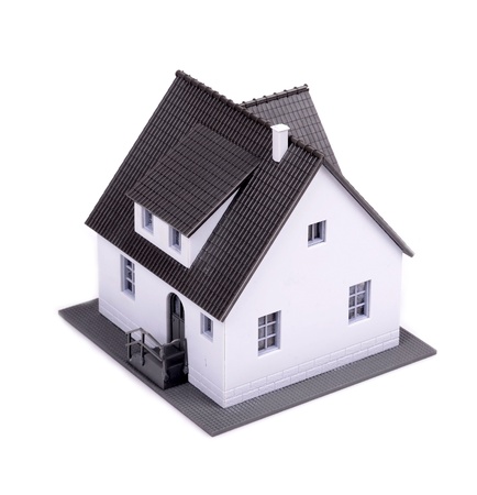 A model of house with dark roof on a white background の写真素材