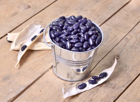 metal bucket  full of black small beans 