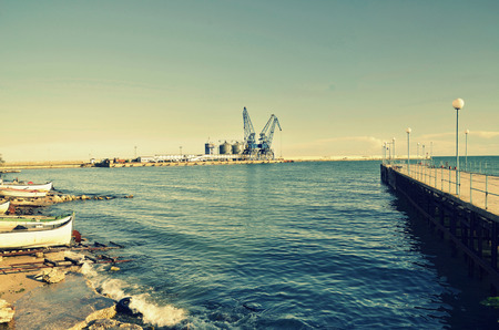 Commercial docks at sunset with a boat and cranes ,selective focus, Balchik, Bulgariaの写真素材