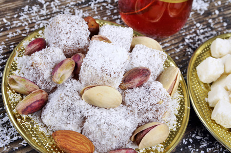 Turkish delight with coconut and dried coconut on wooden tableの写真素材
