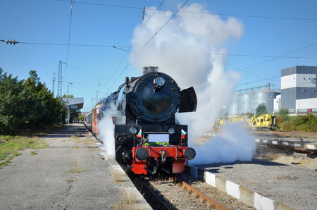 Retro steam train departs from the railway stationの写真素材