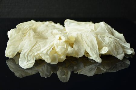 Coronavirus concept.Disposable white medical latex gloves on black background.Hygiene rules during the coronavirus epidemic. Healthcare equipment concept.の写真素材
