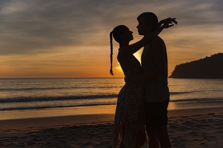Romantic lovers hugging at twlilight with sunset in backgroundの写真素材
