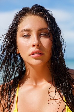 Close up portrait of attractive young woman on the beach. Young caucasian female model posing on the sea shore.の写真素材