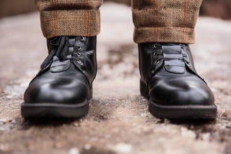 Female feet in black boots, winter walking in snowの写真素材