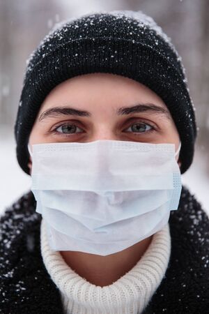 Alarmed female traveler wears medical mask to protect against coronavirus, afraid of infection.の写真素材