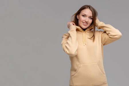 Woman in gold hoodie, mockup for logo or branding designの写真素材