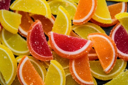 Decorative marmalade candy Background. Pattern of marmalade in shape of citrus fruits wedges. Jelly sweet candies.の写真素材