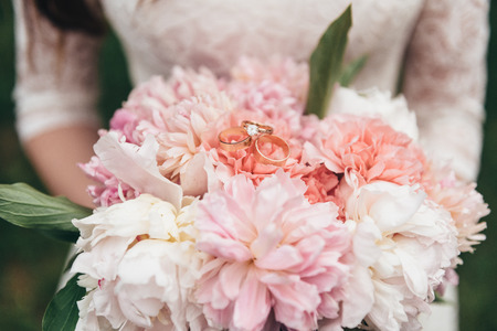 Wedding bouquet of expensive fresh flowers in the hands of the brideの写真素材