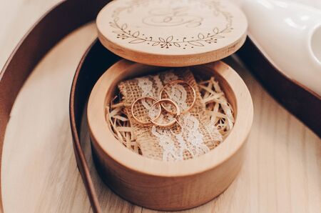 Wooden box in which gold wedding rings are on sackcloth and sawdustの写真素材