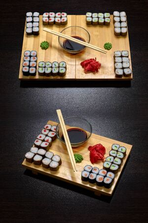 Tasty and delicious hot and cold sushi rolls on the table. Different sushi - rolls with sauce on the board of Japanese cuisine.の写真素材