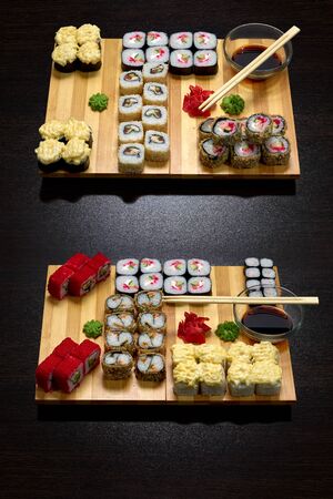 Tasty and delicious hot and cold sushi rolls on the table. Different sushi - rolls with sauce on the board of Japanese cuisine.の写真素材