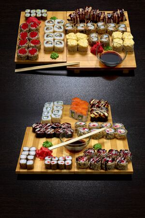 Tasty and delicious hot and cold sushi rolls on the table. Different sushi - rolls with sauce on the board of Japanese cuisine.の写真素材