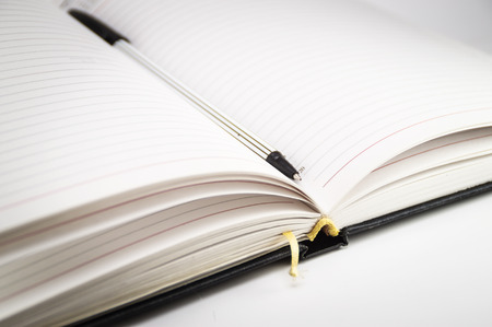 Open notebook with bookmark and pen closeup on a white background. Photo.