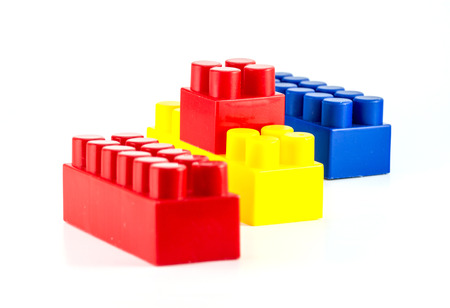Colorful plastic toy blocks close-up isolated on white background.