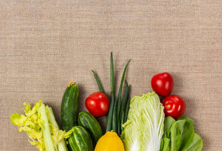 Different vegetables on burlap background and copy space. Healthy vegan and vegetarian eating...