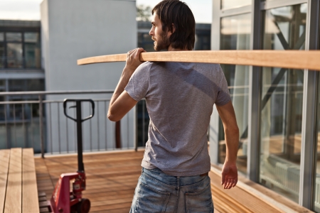 Construction worker holding wooden beamの写真素材