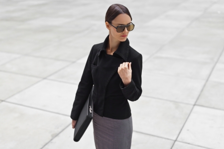 A beautiful young business woman posing on a gray backgroundの写真素材