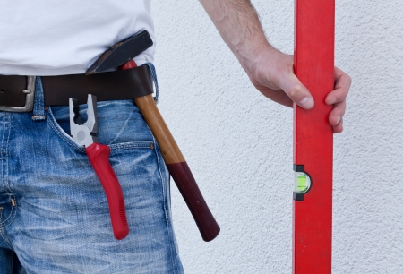 Carpenter holds level over white background
