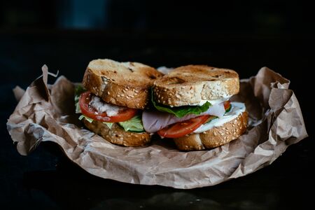Sandwich on craft papper with black backgroundの写真素材