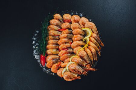 shrimps with lemon and black pepper on dark backgroundの写真素材
